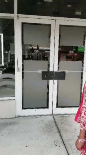 A Woman Stands In Front Of A Door That Says Duban GIF