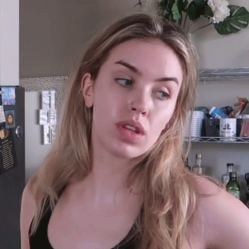A Woman Stands In Front Of A Fridge With A Sticker On It That Says ' Ice Cream ' On It GIF