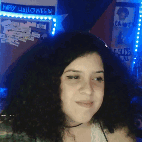 A Woman Stands In Front Of A Happy Halloween Sign GIF