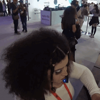 A Woman Stands In Front Of A Logitech Display GIF