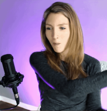 A Woman Stands In Front Of A Microphone With Her Arms Crossed GIF