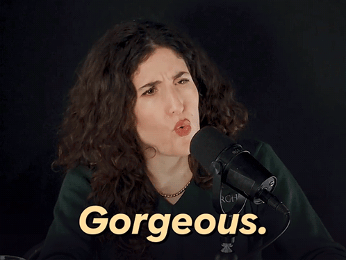 A Woman Stands In Front Of A Microphone With The Word Gorgeous In Yellow GIF