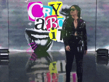 A Woman Stands In Front Of A Poster That Says Cry About GIF