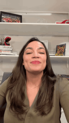 A Woman Stands In Front Of A Shelf With A Picture Of A Ring On It GIF