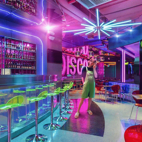 A Woman Stands In Front Of A Sign That Says Disco GIF