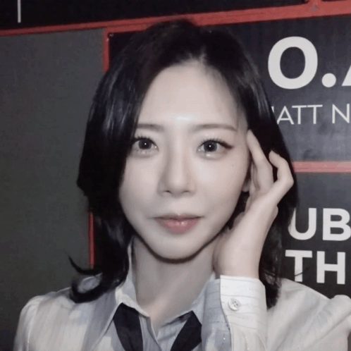 A Woman Stands In Front Of A Sign That Says O.a. Att N. GIF