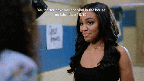 A Woman Stands In Front Of A Sign That Says " Over Fruits " GIF