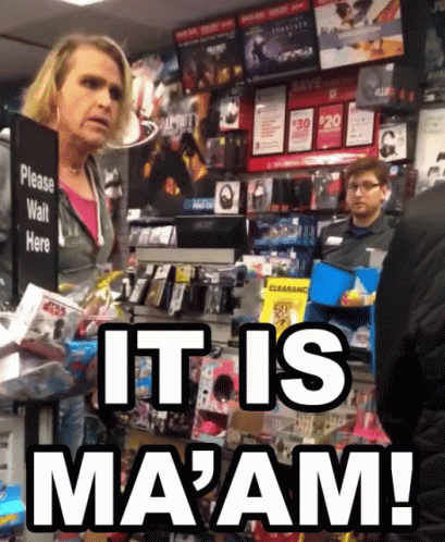 A Woman Stands In Front Of A Sign That Says Please Wait Here GIF