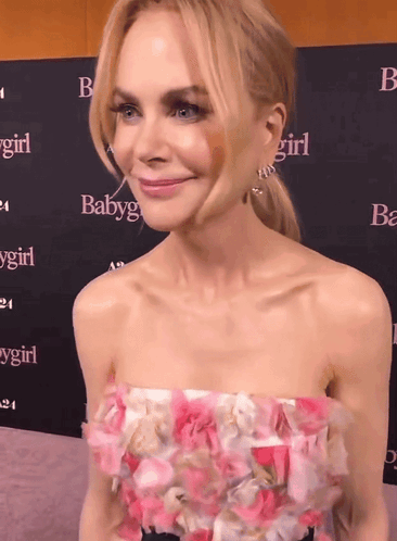 A Woman Stands In Front Of A Wall That Says Baby Girl GIF