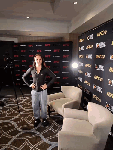 A Woman Stands In Front Of A Wall That Says Ufc On It GIF