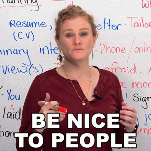 A Woman Stands In Front Of A White Board With The Words Be Nice To People On It GIF