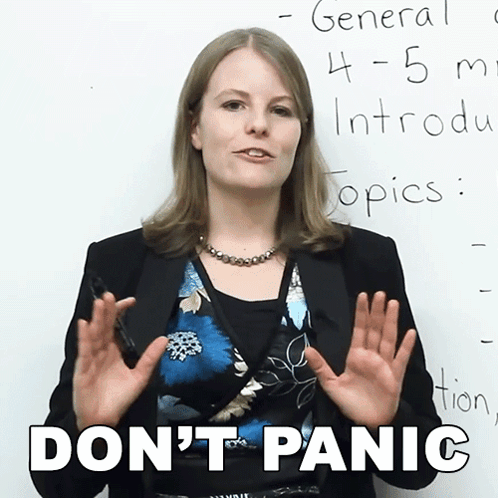 A Woman Stands In Front Of A White Board With The Words " Don 'T Panic " Written On It GIF