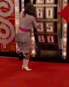 A Woman Stands On A Red Carpet In Front Of A Machine That Says 60 GIF