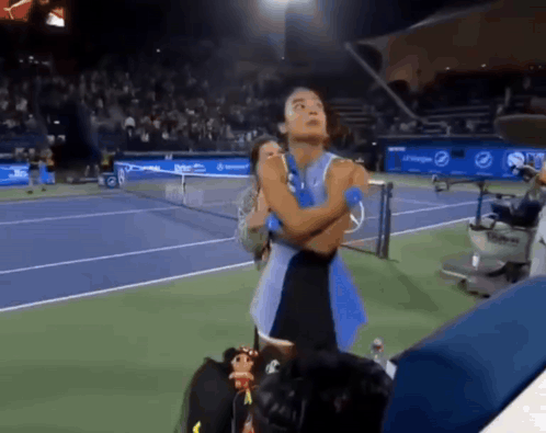 A Woman Stands On A Tennis Court With Her Arms Crossed In Front Of A Pepsi Banner GIF