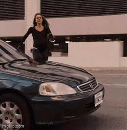 A Woman Stands On The Hood Of A Blue Honda GIF