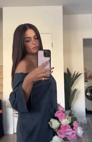 A Woman Taking A Picture Of Herself In The Mirror GIF