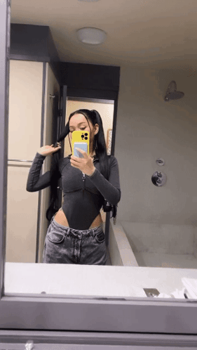 A Woman Taking A Selfie In A Bathroom Mirror GIF