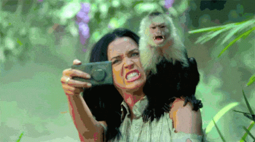 A Woman Taking A Selfie With A Monkey On Her Shoulder GIF