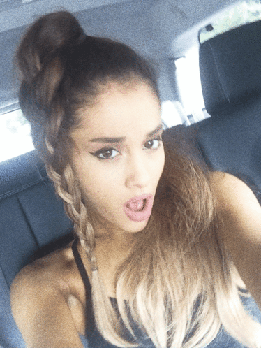 A Woman Taking A Selfie With Her Hair In A Bun GIF