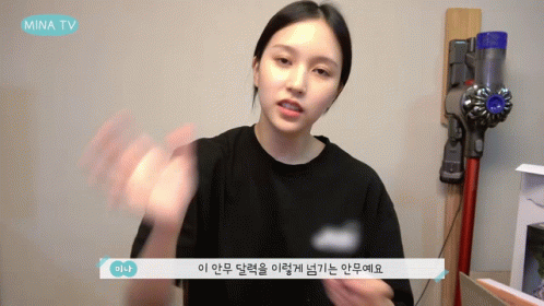 A Woman Talking In Front Of A Vacuum Cleaner That Says Mina Tv On It GIF