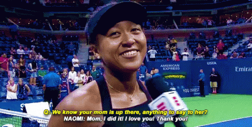 A Woman Talking Into A Microphone On A Tennis Court In Front Of An American Express Sign GIF