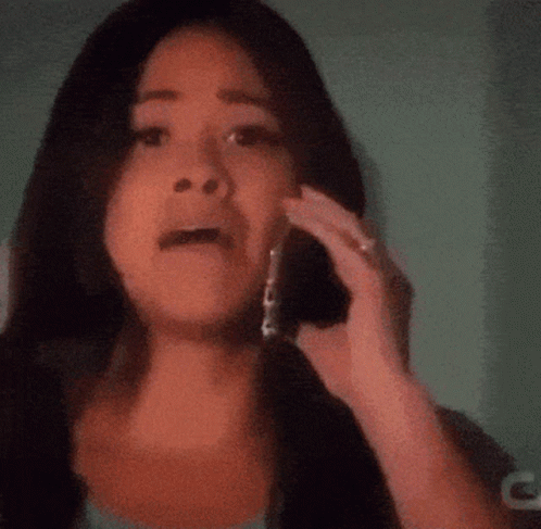 A Woman Talking On A Cell Phone With A Blurred Background GIF