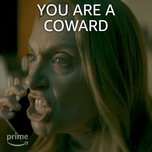 A Woman Talking On A Phone With The Words " You Are A Coward " Written Above Her GIF
