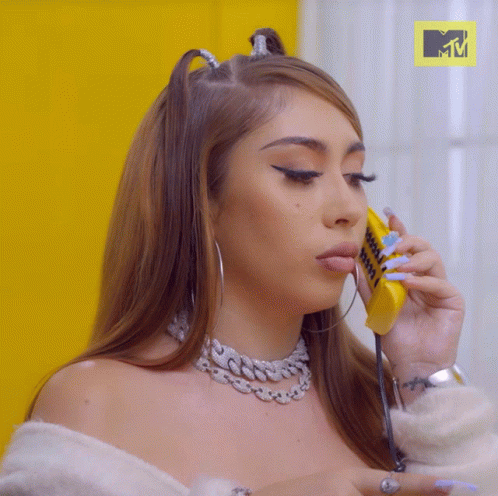 A Woman Talking On A Yellow Phone With A Mtv Logo In The Background GIF