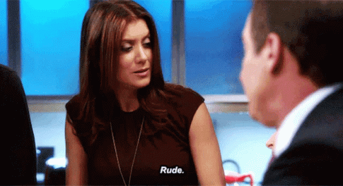 A Woman Talking To A Man With The Word Rude On Her Shirt GIF