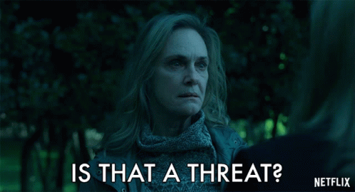 A Woman Talking To Another Woman With The Words Is That A Threat Written Below Her GIF