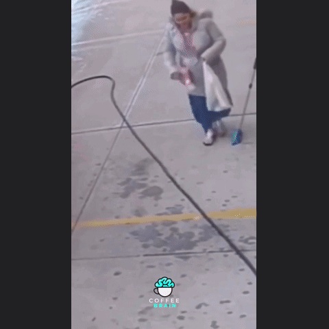 A Woman Walking Down A Sidewalk With A Coffee Bean Logo On The Bottom GIF