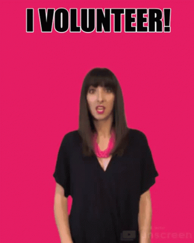 A Woman Waves Her Hand In Front Of A Pink Background With The Words I Volunteer GIF