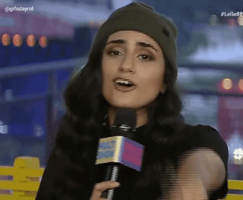 a woman wearing a beanie and holding a microphone with the hashtag lollobr on the bottom right