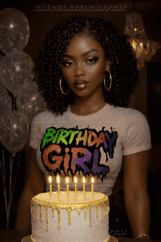 a woman wearing a birthday girl shirt stands in front of a cake with lit candles