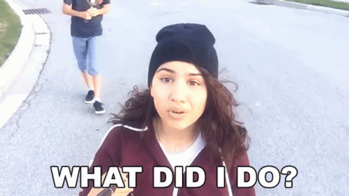 A Woman Wearing A Black Beanie Is Asking What Did I Do . GIF