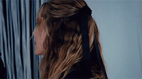 A Woman Wearing A Black Bow In Her Hair GIF