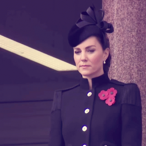 A Woman Wearing A Black Coat And A Black Hat GIF