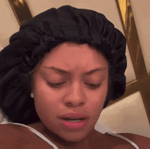 A Woman Wearing A Black Hair Bonnet Looks Tired GIF