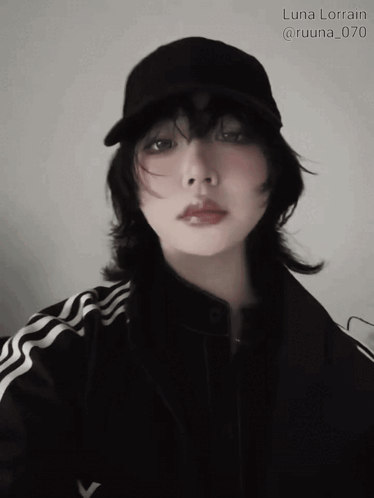 A Woman Wearing A Black Hat And A Black Jacket Has The Name Luna Lorain Written Above Her GIF