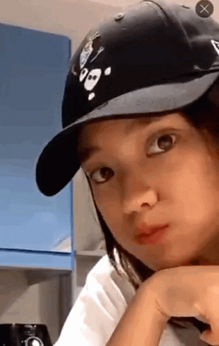 A Woman Wearing A Black Hat With A Skull And Crossbones On It GIF