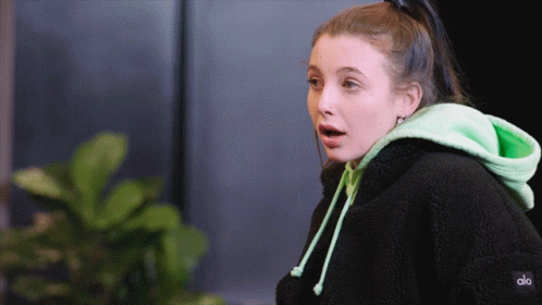 A Woman Wearing A Black Hoodie And A Green Hoodie That Says Alo GIF