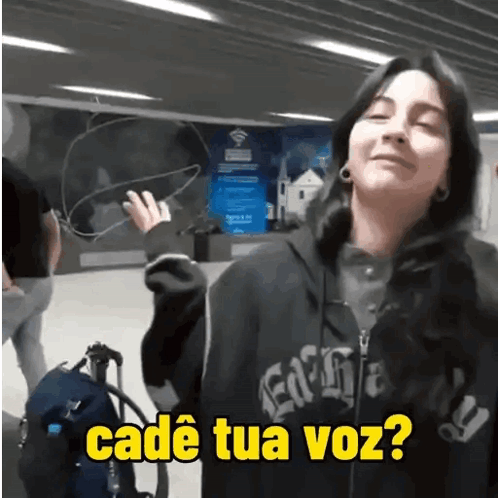 A Woman Wearing A Black Hoodie With The Words Cadé Tua Voz On It GIF