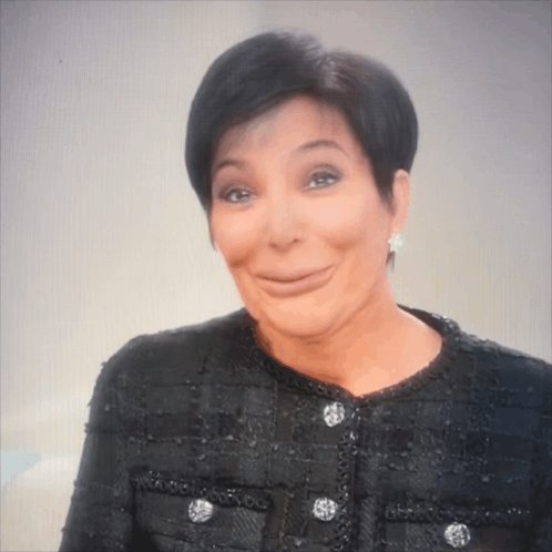 A Woman Wearing A Black Jacket And Earrings Is Making A Face GIF