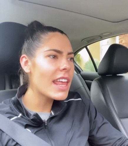 A Woman Wearing A Black Jacket Is Sitting In A Car GIF