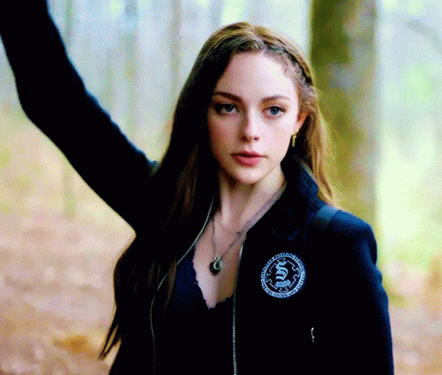 A Woman Wearing A Black Jacket With A Badge That Says ' S. ' GIF