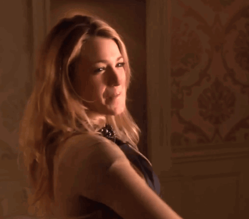 A Woman Wearing A Black Leather Dress And A Brown Cardigan GIF