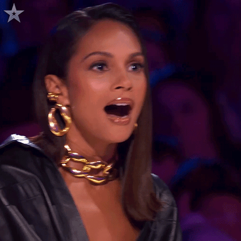 A Woman Wearing A Black Leather Jacket And Gold Hoop Earrings Has Her Mouth Open GIF