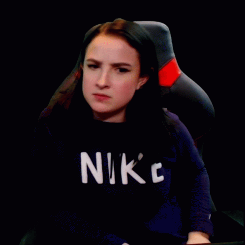 A Woman Wearing A Black Nike Shirt Is Making A Face GIF