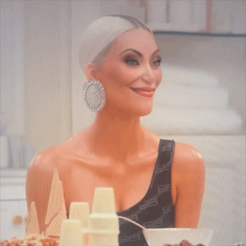 A Woman Wearing A Black One Shoulder Top With The Letters Balenciaga On It GIF