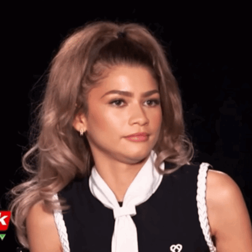 A Woman Wearing A Black Shirt And A White Tie Has A Heart On Her Shirt GIF